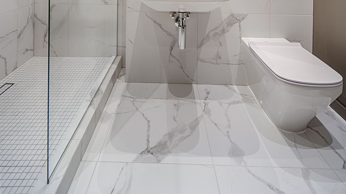 Banheiro de apartamento com pia, vaso sanitário e ralo, ambiente associado à busca pela origem de cheiro de esgoto