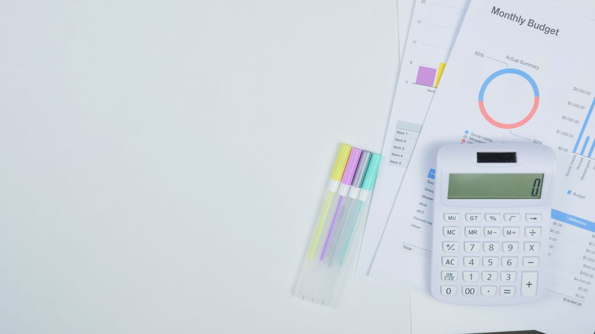 Síndico organizando planilhas e documentos financeiros sobre uma mesa, com calculadora, para montar o orçamento anual do condomínio