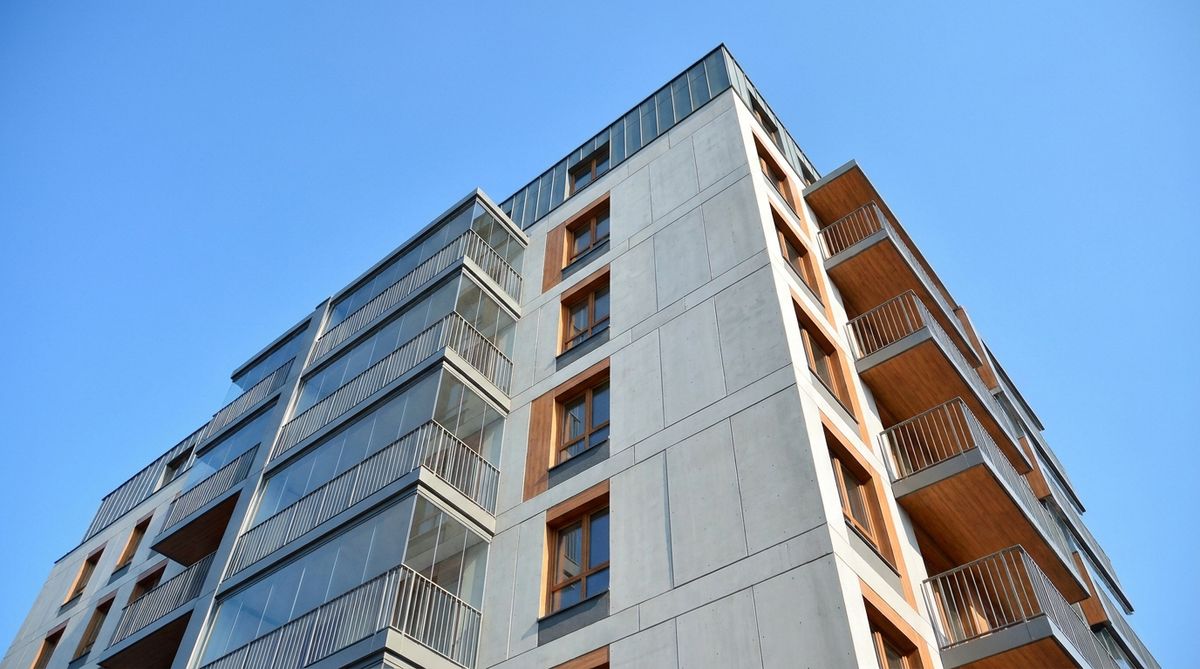 Prédio residencial visto de baixo com céu ao fundo, representando a edificação segurada de um condomínio