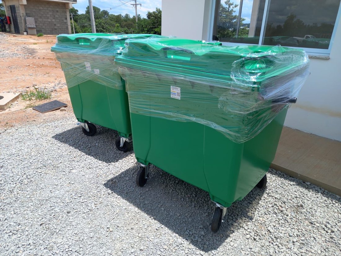 Dois contentores de lixo verdes de 1000 litros, embalados em plástico, prontos para entrega